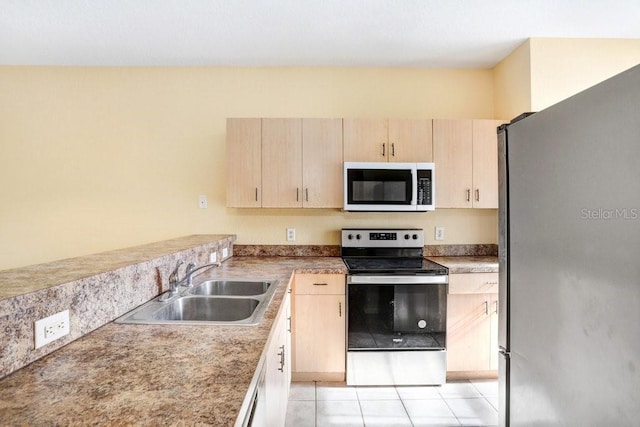 kitchen with light tile patterned flooring, appliances with stainless steel finishes, light brown cabinets, and sink