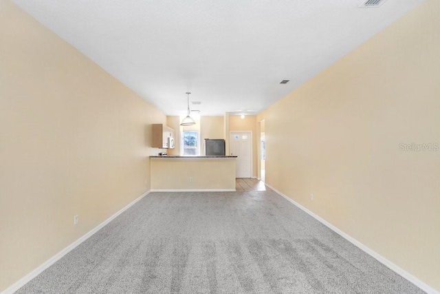 unfurnished living room with light colored carpet