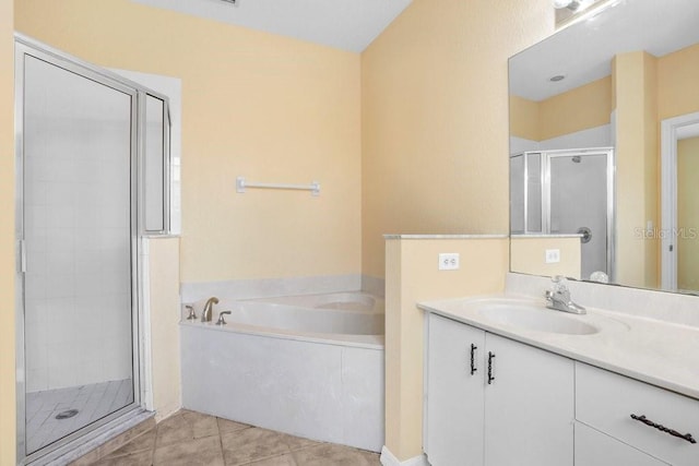 bathroom featuring plus walk in shower, vanity, and tile patterned flooring