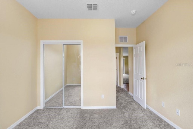 unfurnished bedroom featuring a closet and light carpet