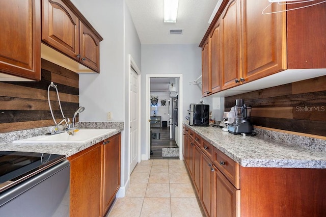 kitchen featuring light stone countertops, sink, and light tile patterned floors