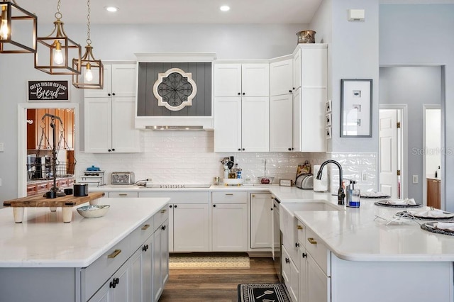 kitchen featuring decorative backsplash, black electric stovetop, hanging light fixtures, and white cabinets