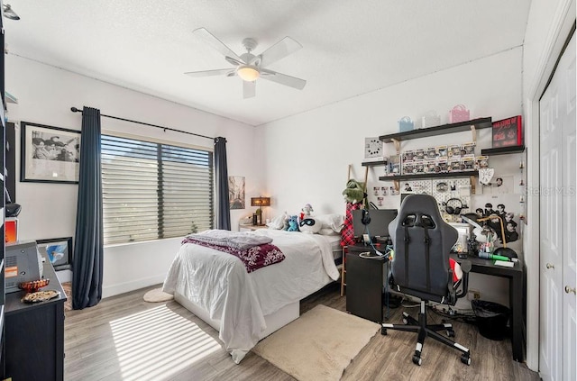 bedroom featuring light wood-type flooring, ceiling fan, and a closet