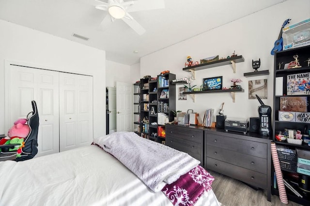 bedroom with ceiling fan, light hardwood / wood-style floors, and a closet