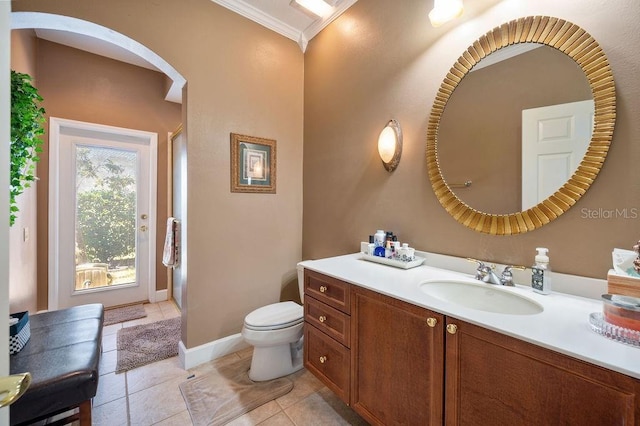 bathroom with tile patterned flooring, ornamental molding, vanity, and toilet