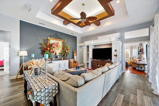 living room featuring a tray ceiling, dark wood-type flooring, and ceiling fan