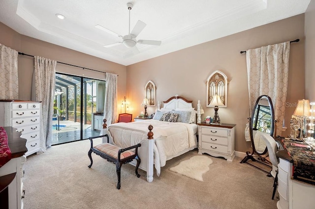 bedroom featuring ceiling fan, a tray ceiling, light colored carpet, and access to outside