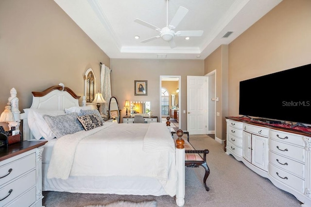 carpeted bedroom with ceiling fan, ornamental molding, and a tray ceiling