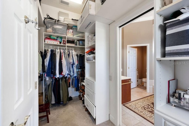 spacious closet with light tile patterned floors