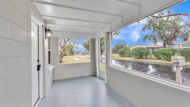 unfurnished sunroom featuring a water view