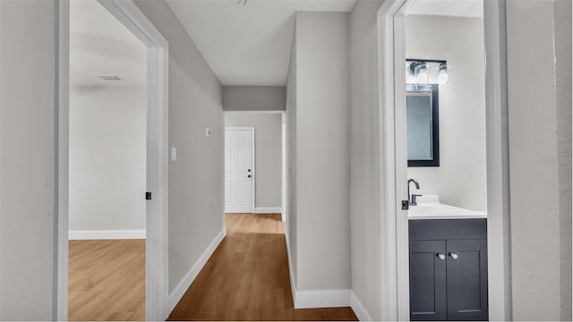 hall featuring sink and hardwood / wood-style floors