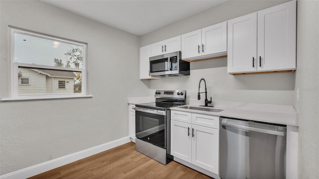 kitchen featuring sink, white cabinets, light hardwood / wood-style floors, and stainless steel appliances