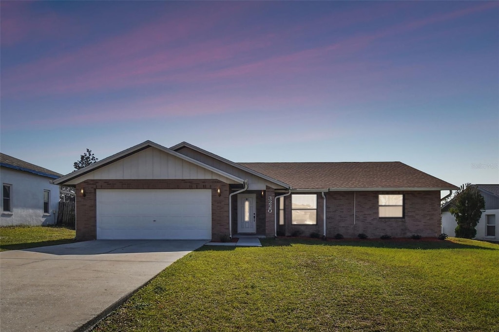 single story home with a garage and a lawn