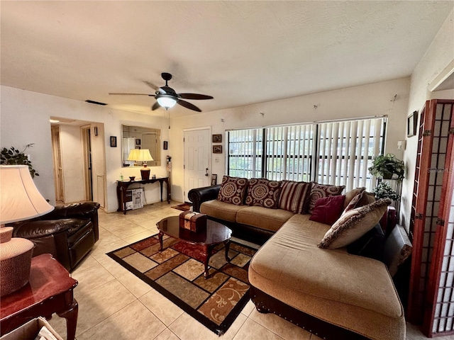 living room featuring a textured ceiling, ceiling fan, and light tile patterned floors