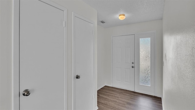 foyer with a textured ceiling and dark hardwood / wood-style flooring