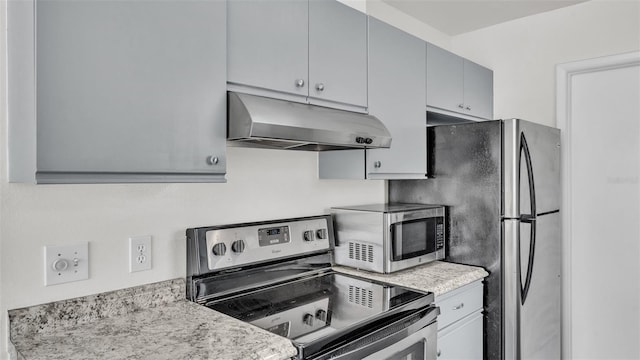 kitchen featuring light stone counters, appliances with stainless steel finishes, and gray cabinets