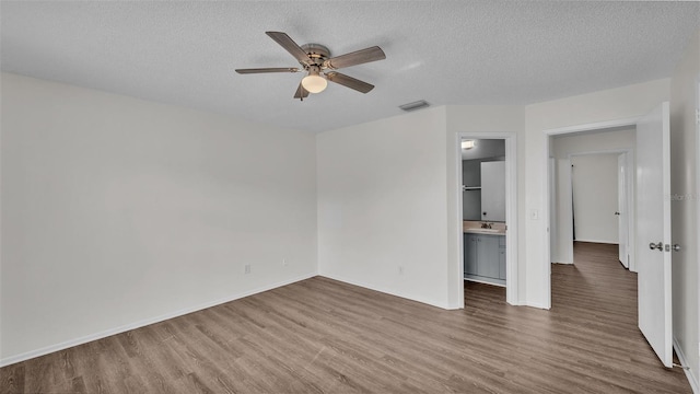 spare room featuring sink, hardwood / wood-style floors, a textured ceiling, and ceiling fan