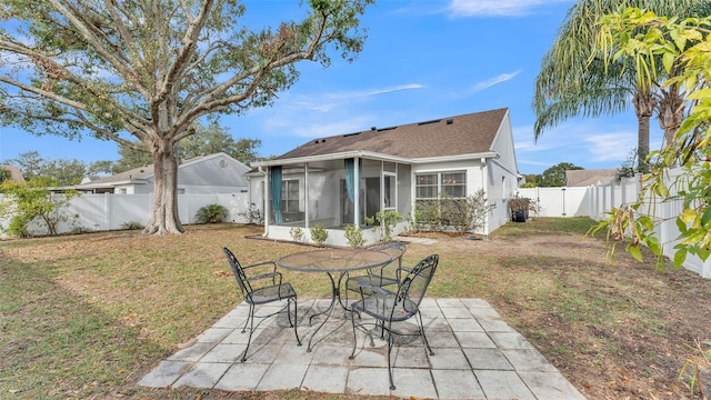 back of house featuring a sunroom, a patio area, and a yard