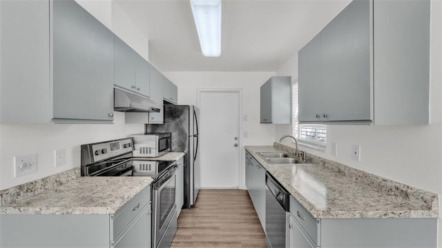 kitchen with light hardwood / wood-style floors, sink, gray cabinets, and stainless steel appliances