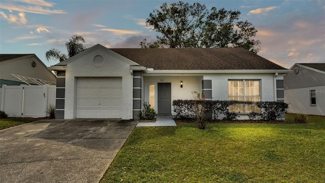 ranch-style house featuring a garage and a yard