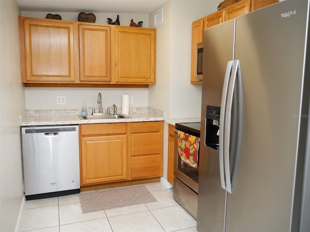 kitchen with stainless steel appliances, light tile patterned flooring, sink, and light stone counters