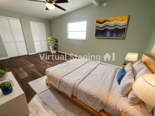 bedroom with lofted ceiling, hardwood / wood-style floors, two closets, and ceiling fan