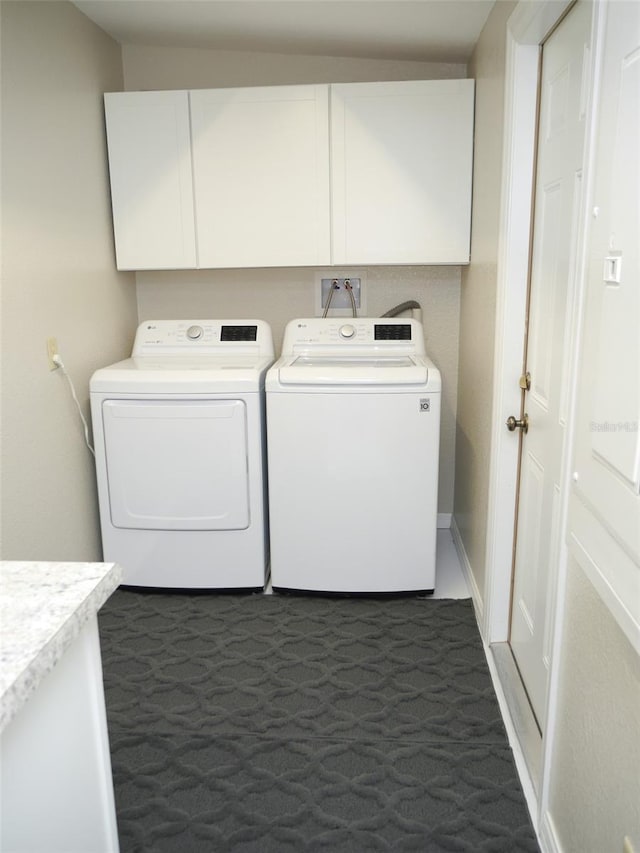 clothes washing area featuring cabinets, dark carpet, and independent washer and dryer