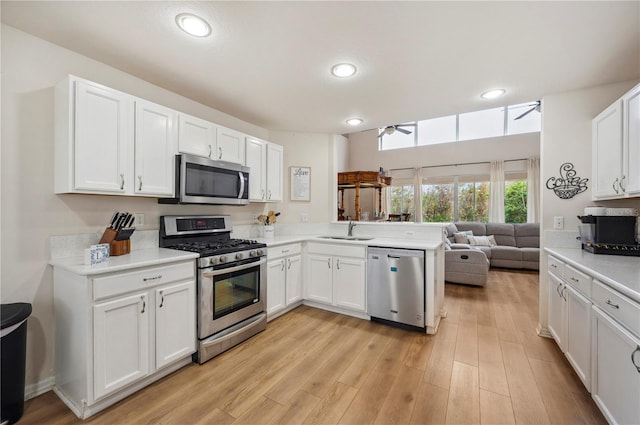 kitchen with ceiling fan, appliances with stainless steel finishes, sink, and white cabinets