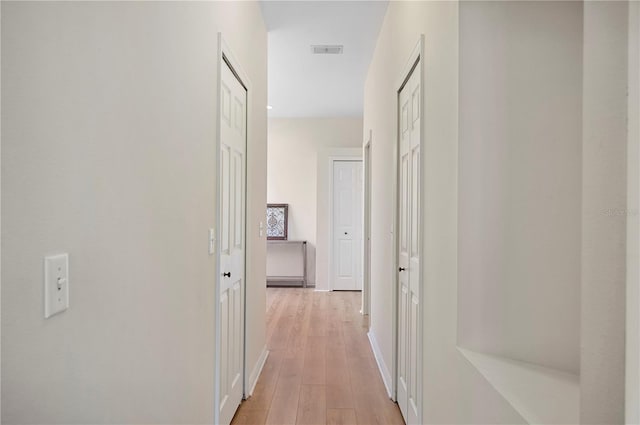 hallway with light hardwood / wood-style floors