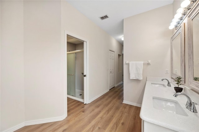 bathroom featuring vanity, an enclosed shower, and hardwood / wood-style flooring