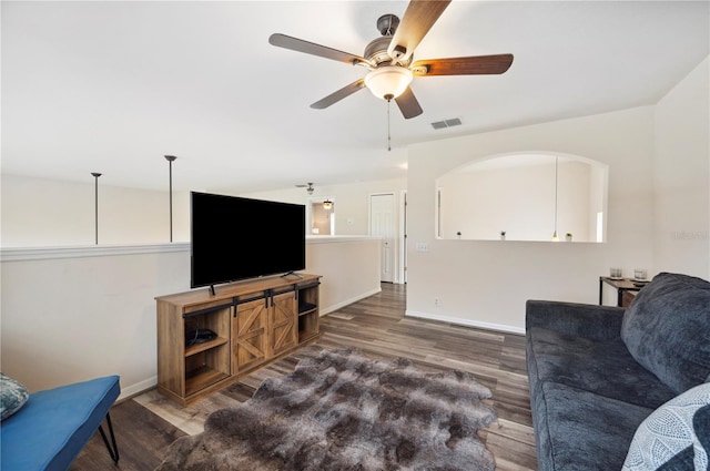 living room with dark wood-type flooring and ceiling fan