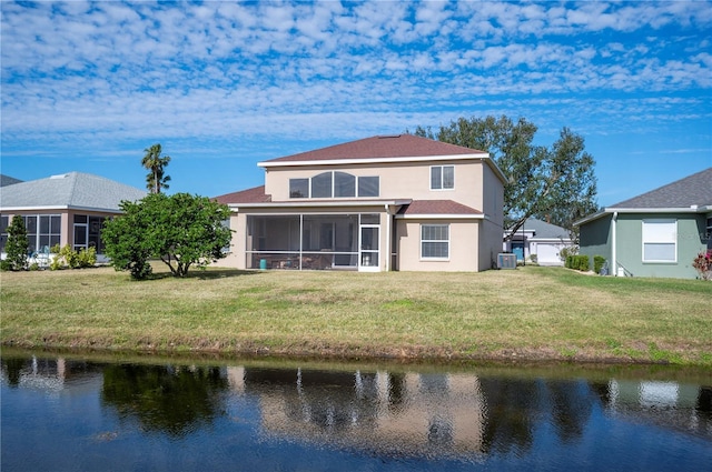 rear view of property featuring a water view, a yard, stucco siding, and a sunroom