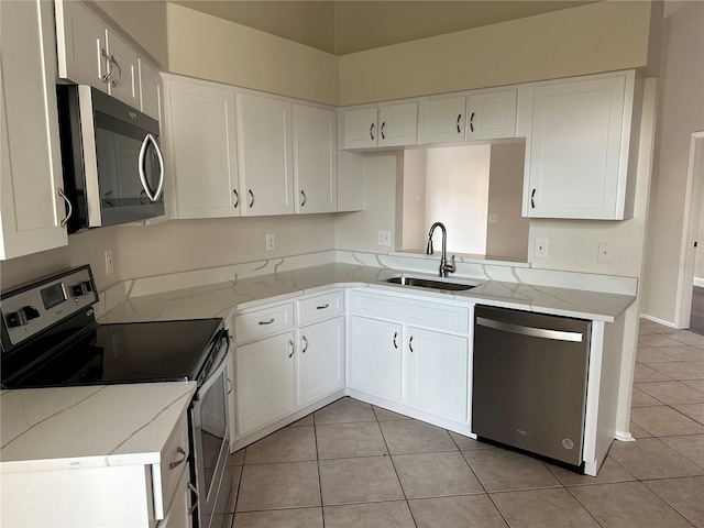 kitchen with sink, white cabinetry, appliances with stainless steel finishes, and light tile patterned flooring