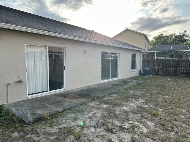 rear view of house with cooling unit, a lanai, and a patio area