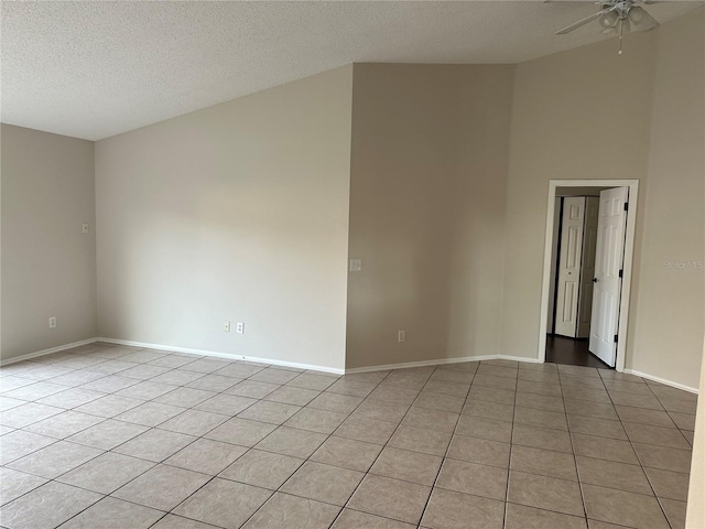 spare room with ceiling fan, light tile patterned floors, and a textured ceiling