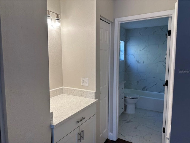 full bathroom featuring toilet, vanity, and tiled shower / bath