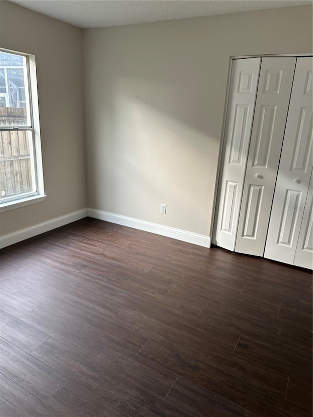 unfurnished bedroom with dark wood-type flooring and a textured ceiling