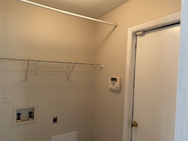 washroom with a textured ceiling, hookup for an electric dryer, and washer hookup