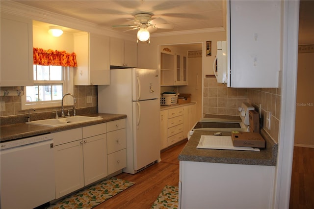 kitchen featuring white cabinetry, sink, light wood-type flooring, backsplash, and white appliances