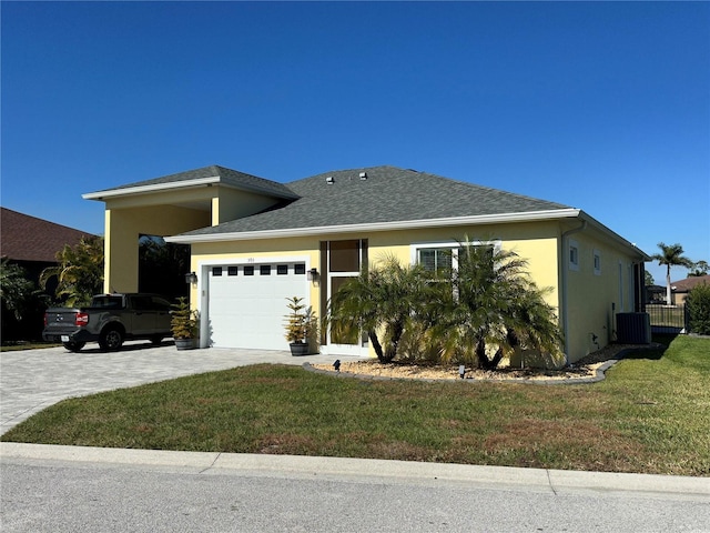 view of front of home with cooling unit, a garage, and a front lawn