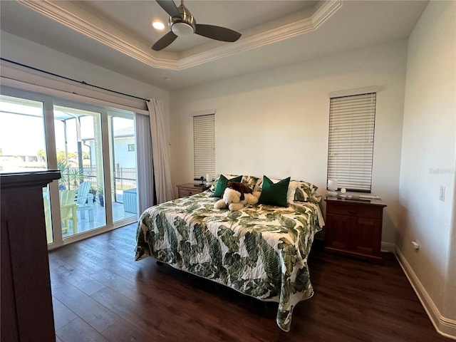 bedroom featuring ornamental molding, a tray ceiling, dark hardwood / wood-style flooring, ceiling fan, and access to exterior