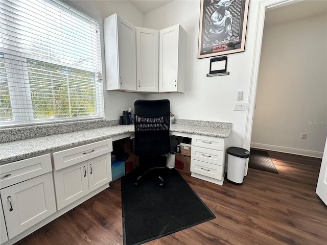 home office featuring dark hardwood / wood-style floors and built in desk