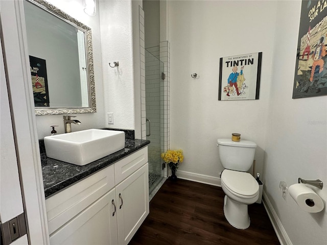 bathroom featuring vanity, hardwood / wood-style floors, an enclosed shower, and toilet