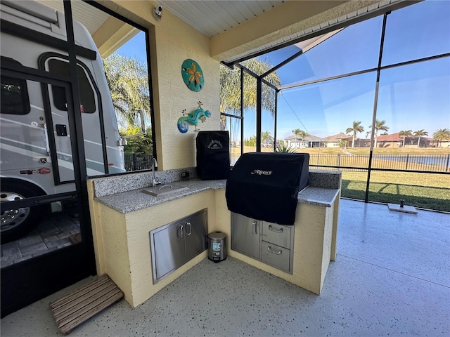 view of patio featuring grilling area, area for grilling, sink, and glass enclosure