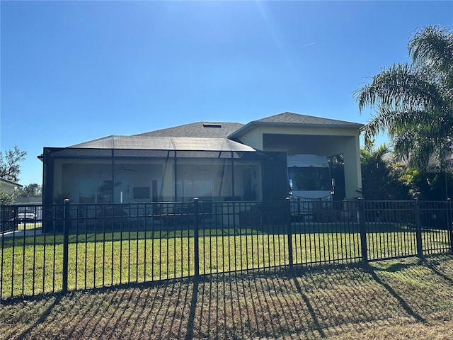 view of front of house with a front yard and glass enclosure