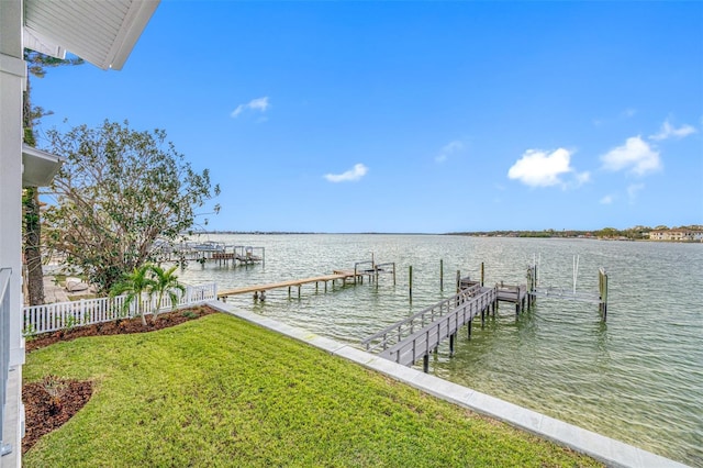 view of dock with a yard and a water view