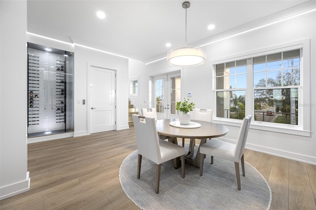 dining area featuring hardwood / wood-style flooring, french doors, and a healthy amount of sunlight