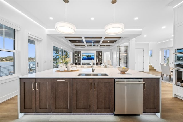 kitchen featuring sink, decorative light fixtures, dark brown cabinetry, and coffered ceiling