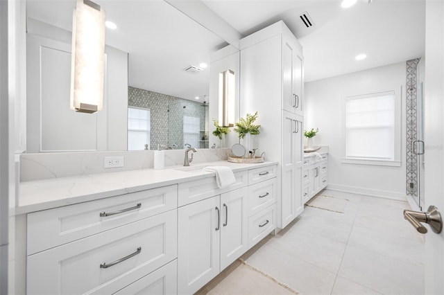 bathroom featuring tile patterned floors, walk in shower, and vanity