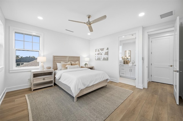 bedroom with ceiling fan, connected bathroom, and wood-type flooring